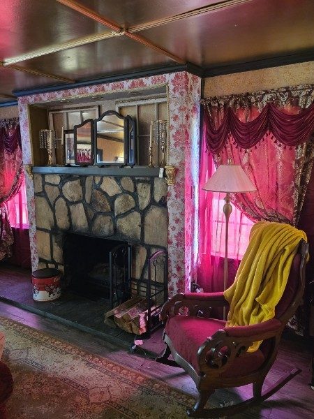 Stone fireplace and ornate curtains in the cabin sitting room